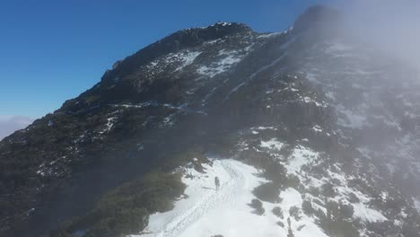 Una-Mujer-Camina-Con-Una-Chaqueta-Roja-En-El-Camino-Nevado-En-La-Cima-De-La-Montaña-Pico-Ruivo-En-Madeira