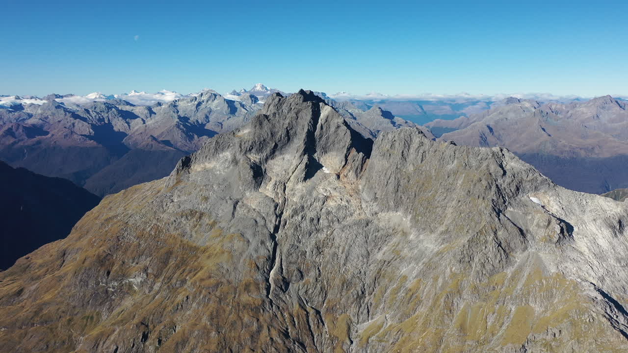 Aerial flying toward a rocky peak in New Zealand's Southern Alps mountains