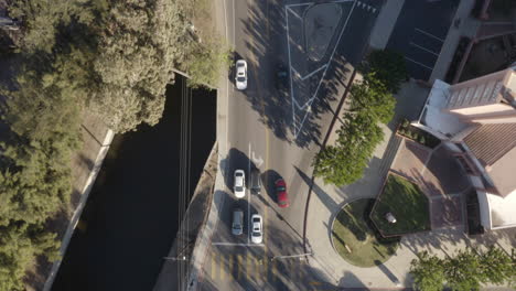 tomada aérea cinematográfica en 4k del río los ángeles y las calles suburbanas circundantes con pájaros iluminados por el sol volando a través del cuadro