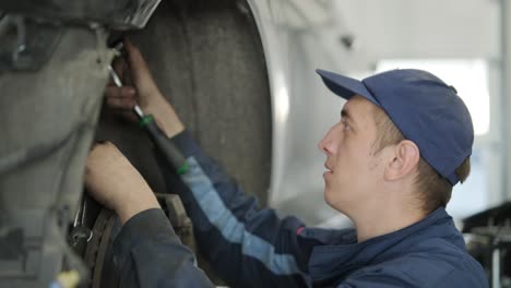 mechanic repairing car suspension