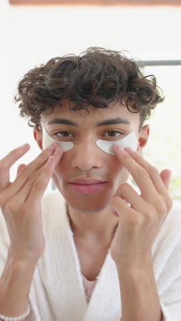 vertical video: applying under-eye patches, person at home focusing on skincare routine