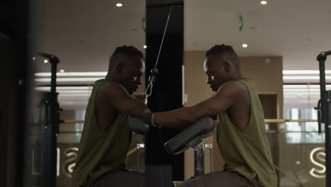 man working out on a cable machine in a gym