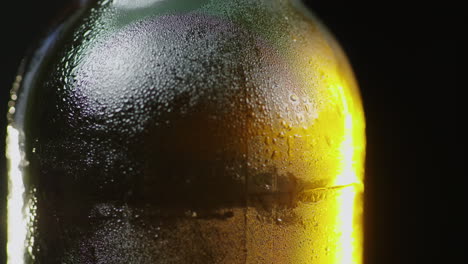 Eine-Glasflasche-Mit-Einem-Kalten-Getränk-Dreht-Sich-Langsam-Tropfen-Kondensierter-Feuchtigkeit-Fließen-Daran-Herunter-Kaltes-Bier-Con