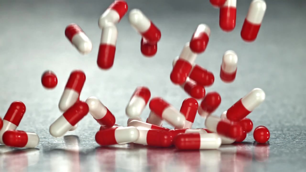 Capsule mediche rosse e bianche che cadono al rallentatore