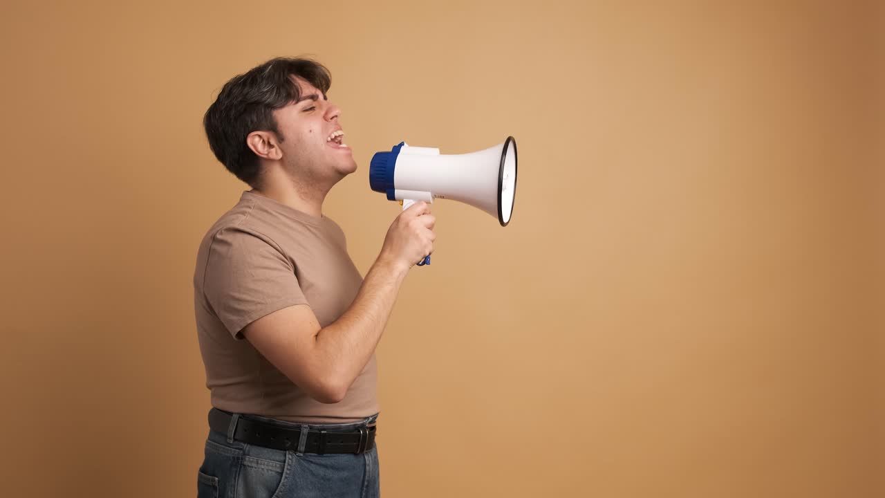 Young man screaming on megaphone during protest