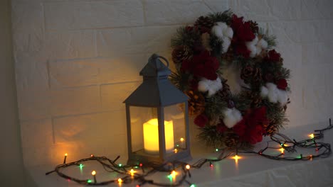 Christmas wreath handmade on a wooden background. Festive lights of garland. New Year&#039;s interior decoration.