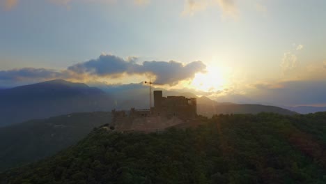 aerial drone left to right tracking shot of montsoriu castle in catalonia, spain, against a beautiful sunset.