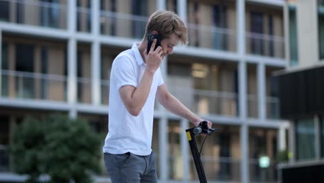 A-businessman-is-talking-on-the-phone-while-getting-on-his-e-scooter