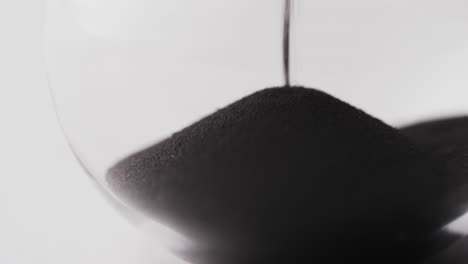 video of close up of hourglass with sand pouring, copy space on white background