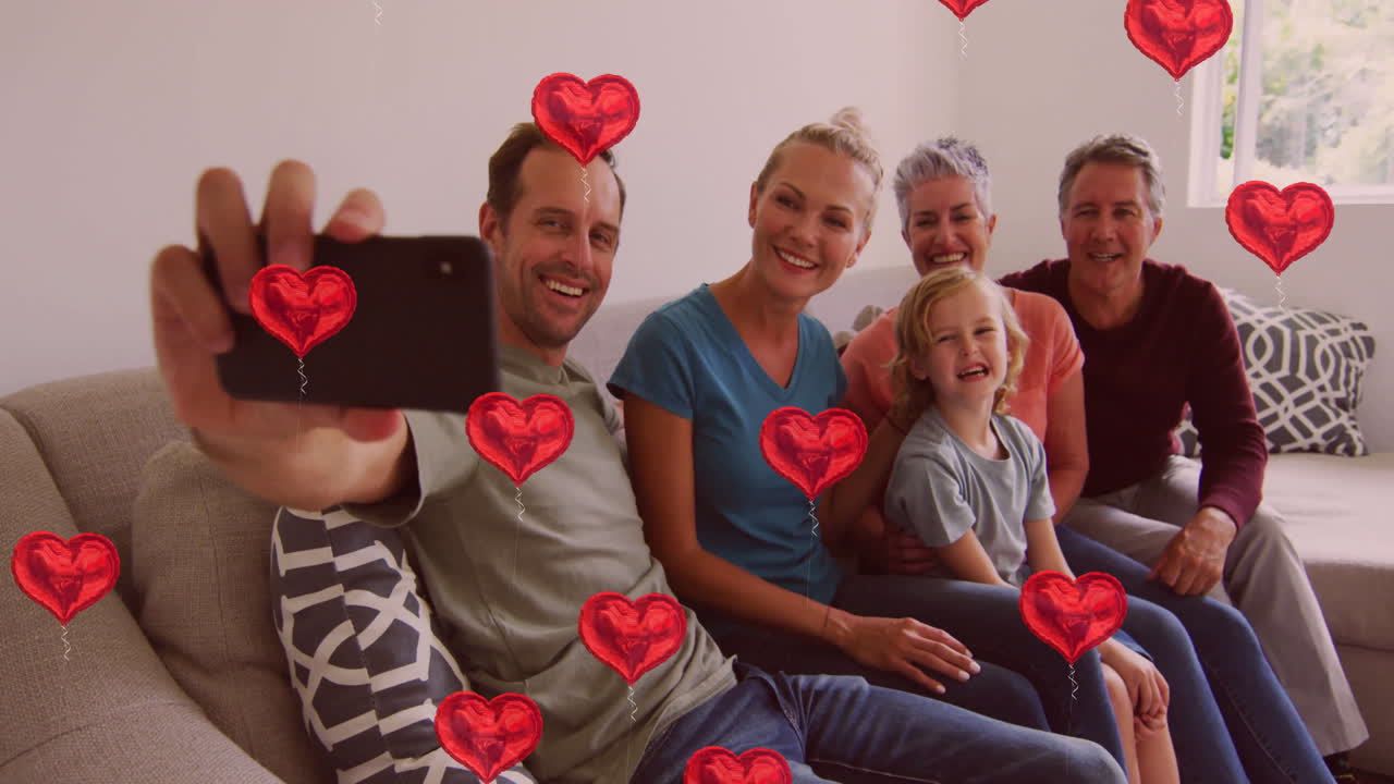 셀피를 찍고, 가족들이 소파에 앉아서 빨간 심장 애니메이션을 떠다니고 있습니다.