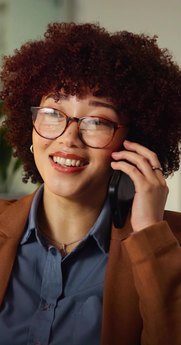 Giovane professionista donna che parla al smartphone in ufficio