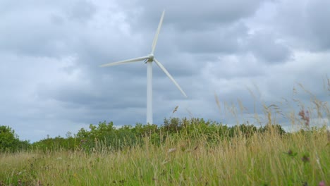 Aerogenerador-Con-Cielo-Tormentoso-Y-Enfoque-De-Hierba-Baja