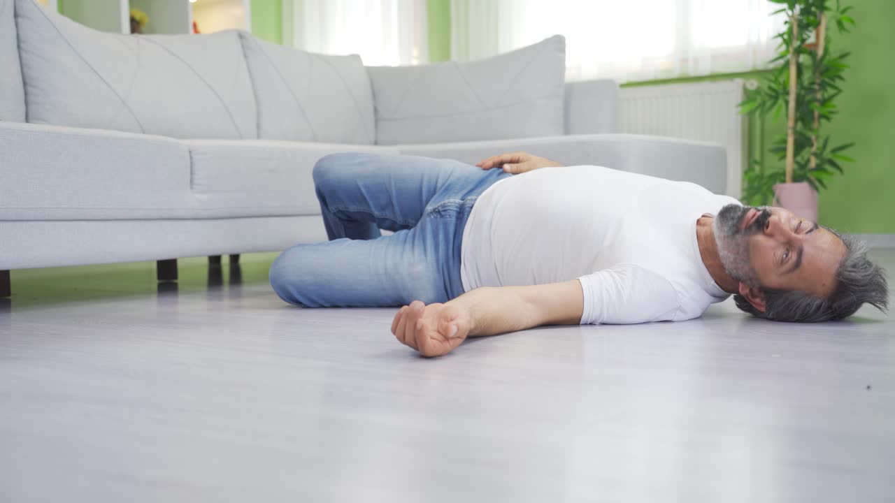 성숙한 남자가 집에서 간질 발작을 일으키고 있습니다.