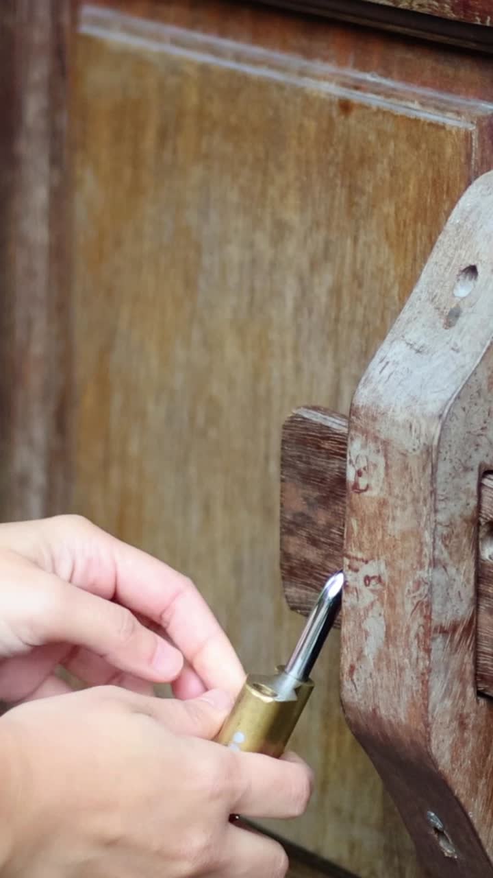 나무 문 에 있는 은 잠금 을 열고 있는 손 들