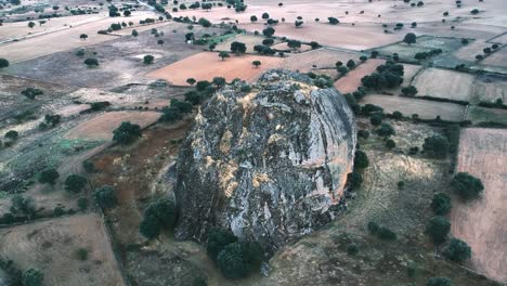 Aerial-shot-of-a-gigantic-rock-on-flat-terrain