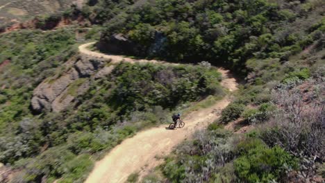 disparo de drone de ciclista de montaña montando un sendero en el condado de orange
