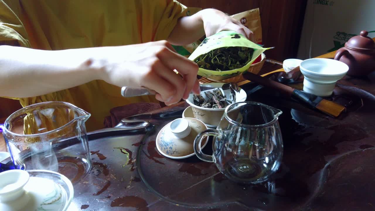 A closeup shot of a woman preparing freshly brewed hot tea from in a traditional Chinese way