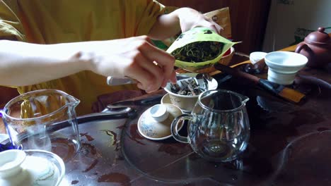 a closeup shot of a woman preparing freshly brewed hot tea from in a traditional chinese way