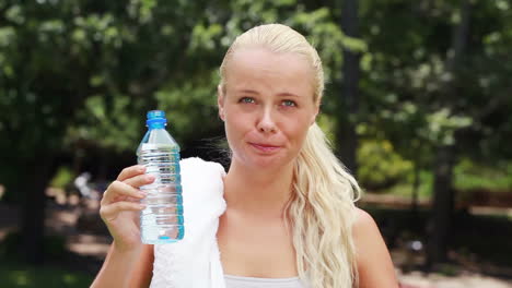 una mujer toma un sorbo de agua se limpia la cabeza antes de beber de nuevo