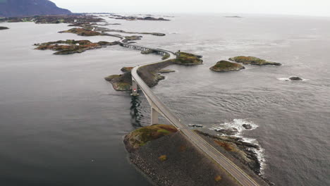 Hermosa-órbita-Aérea-De-La-Carretera-Del-Océano-Atlántico-Y-El-Puente-Storeeisundet,-Noruega