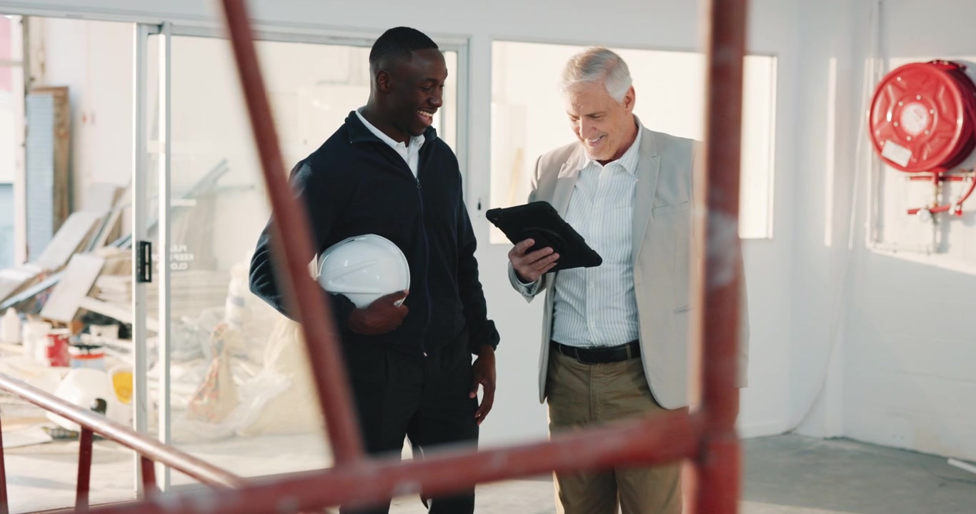 Architect and Construction Worker Discussing Plans on Tablet at Building Site