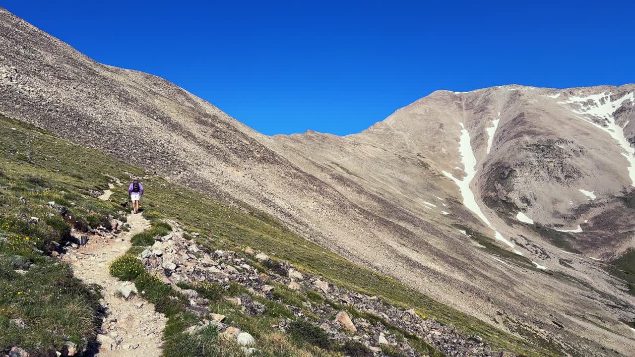 Hiker Mt Mount Princeton hiking trail 14er spring summertime Buena Vista Salida Colorado Sawatch Range melting snow fields Rocky Mountains blue clear sky morning windy breeze summit static
