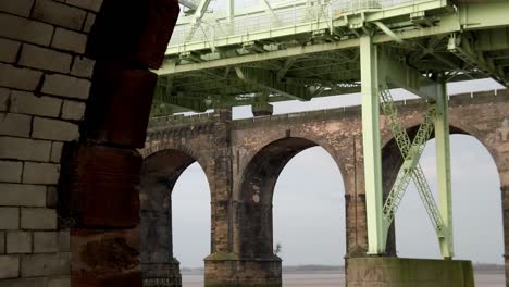 Brick-arches-railway-crossing---Runcorn-silver-jubilee-bridge-parallax-from-behind-old-industrial-brickwork-wall