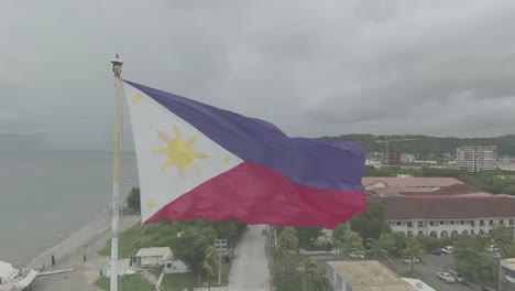 the philippine flag flutters vibrantly, its fabric catching the light as it ripples.