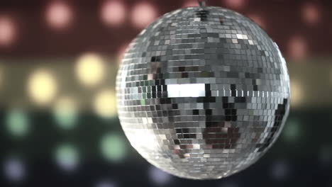 bola de discoteca girando contra la bandera del orgullo gay