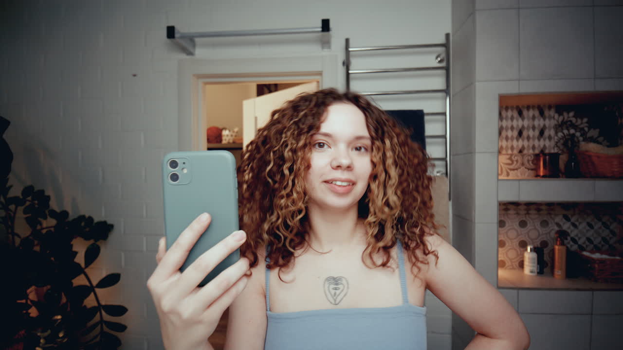 blogger de la generación z grabando un vlog de cuidado de la piel con el teléfono en el baño