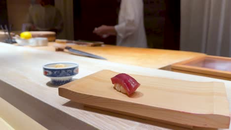 chopsticks pick sushi from wooden board