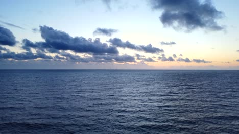 drone shot calm blue ocean water at sunset