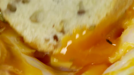 macro shot sumergiendo pan integral en yema de huevo frita cremosa