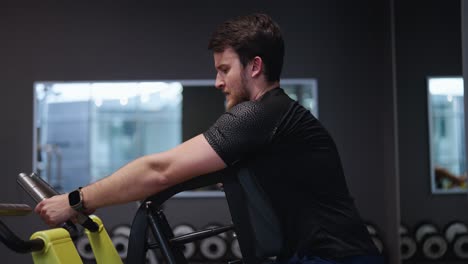 bearded male do last repetition on leverage low row machine for back training