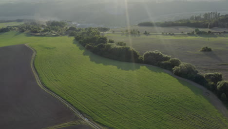 aerial shot of farm land and mountains at sunrise, natural rural czech republic landscape