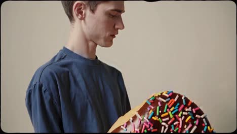 persona sosteniendo una rosquilla gigante y salpicada