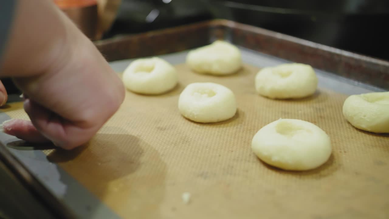 Pressing an Indentation into Sugar Cookies to Make Room for Jam