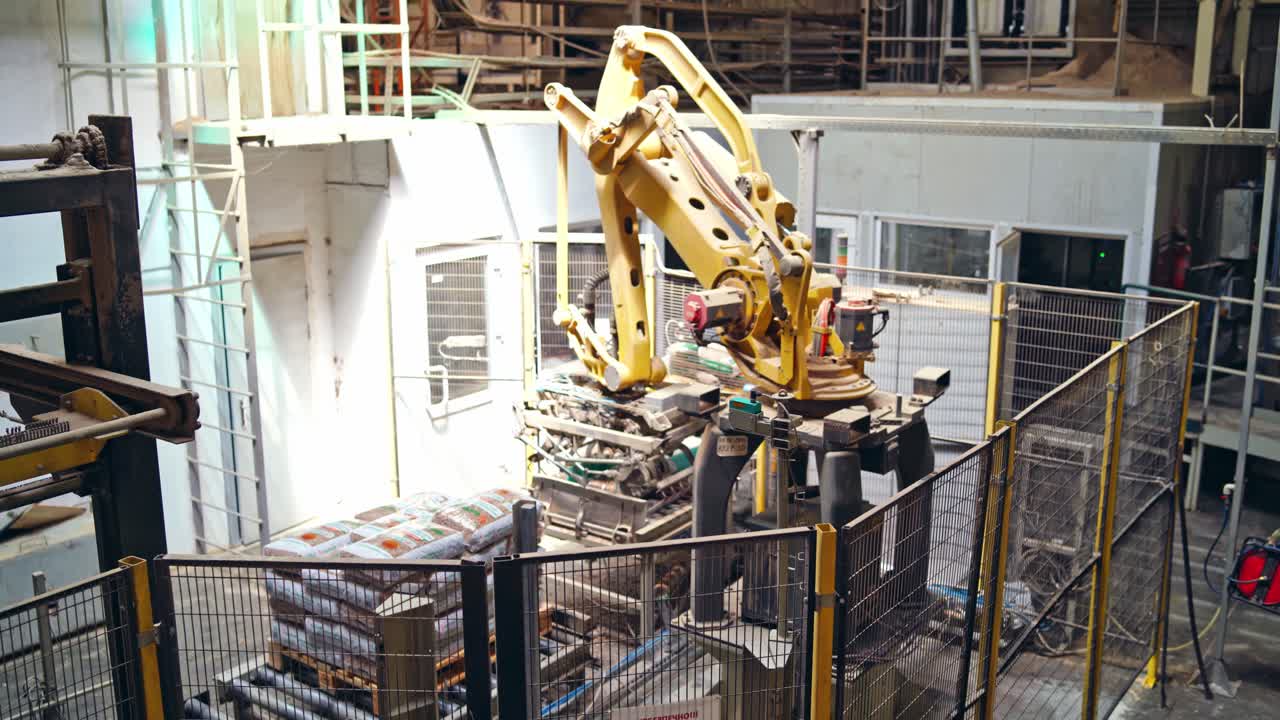 Automated plant indoors. Robotic construction puts the bags on a support on industrial factory background.