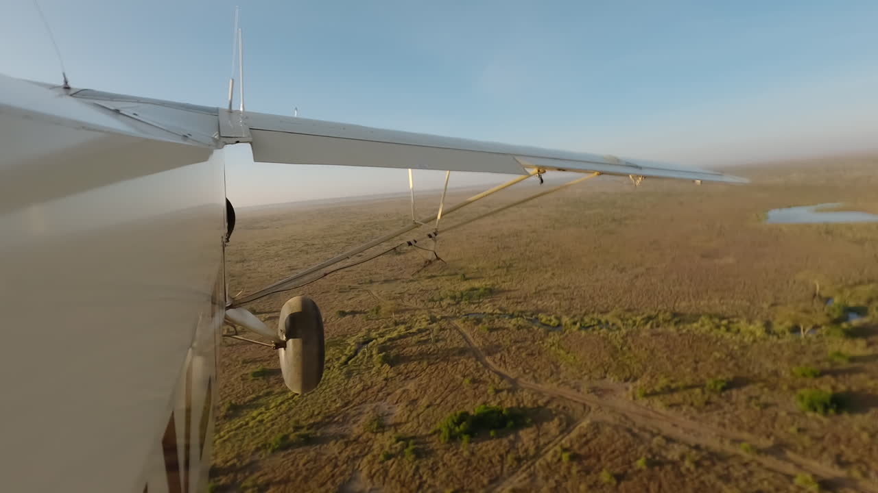 Hyperlapse einer weiten Luftaufnahme eines Flugzeugs über verstreuten Sträuchern