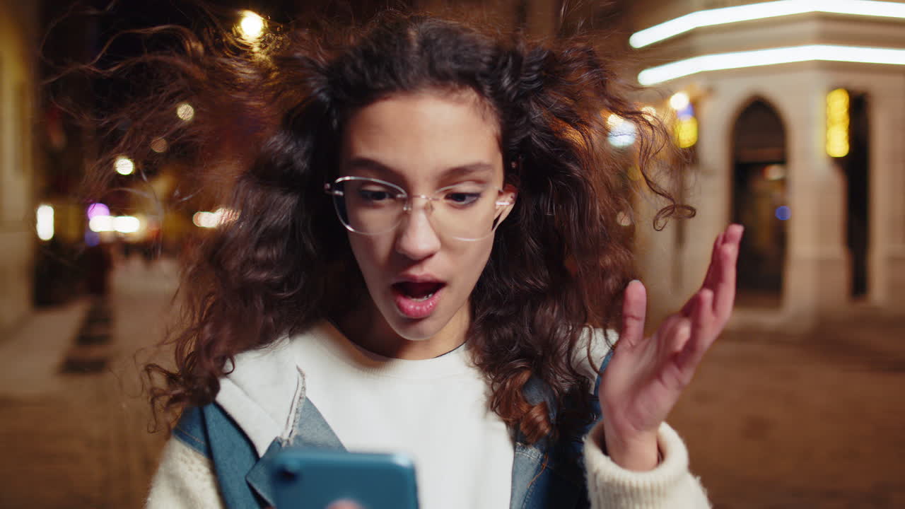 chica feliz usando teléfono inteligente escribiendo navegando celebrando ganar buenas noticias de mensajes en la calle de la ciudad
