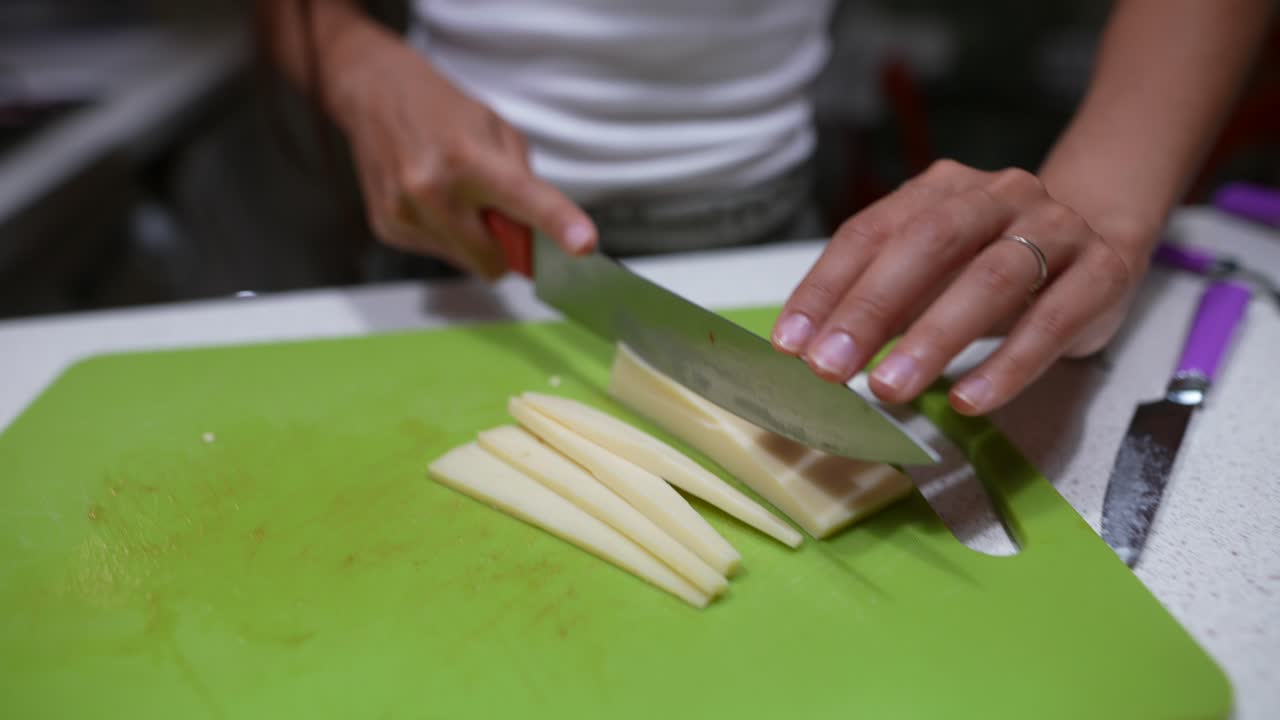 mujer cortando queso en una cocina