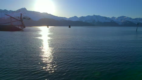 avión no tripulado volando sobre el agua hacia las montañas y el amanecer en seward alaska
