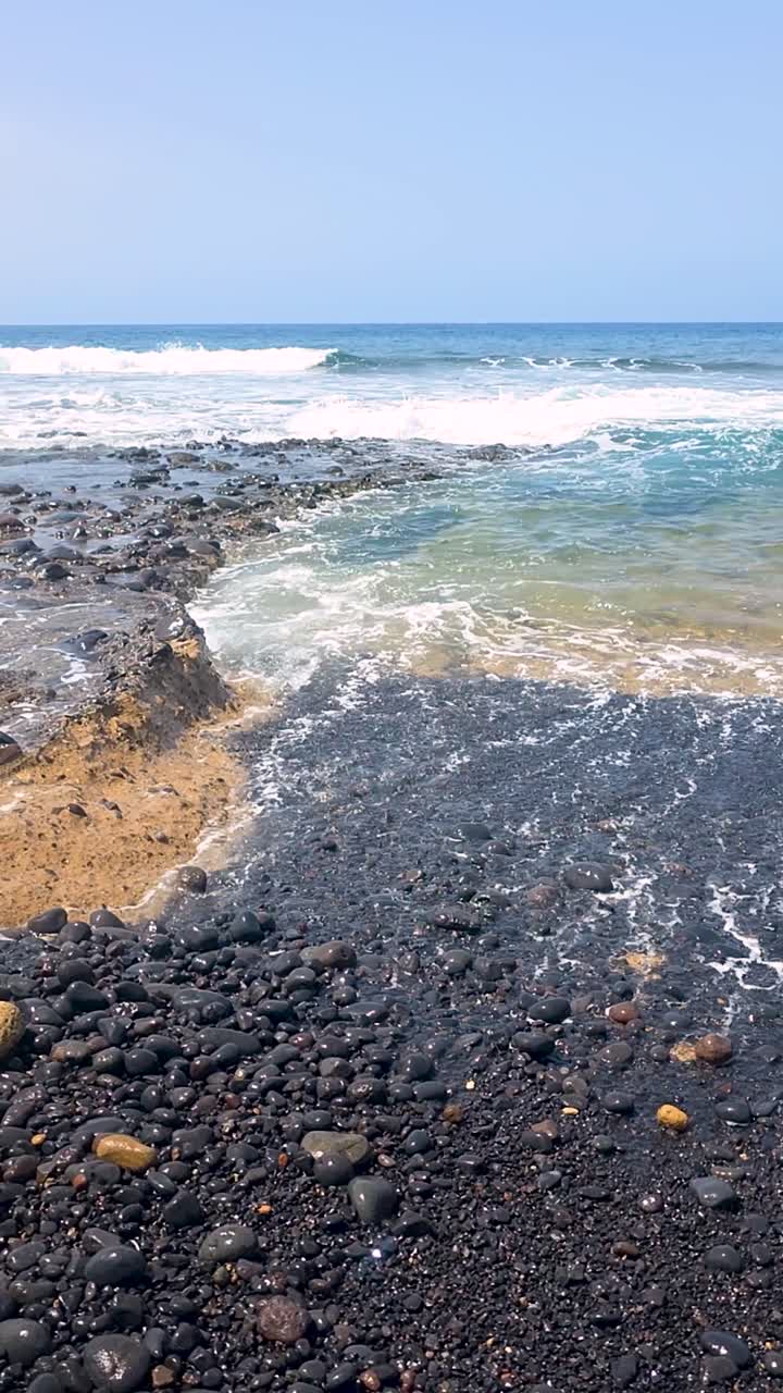 Onde dinamiche si infrangono sulle rocce vulcaniche nere della costa di Tenerife. Ideale per spot pubblicitari di viaggio o documentari naturalistici che mostrano paesaggi costieri aspri.
