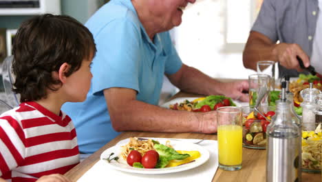 una familia feliz de varias generaciones comiendo en la mesa