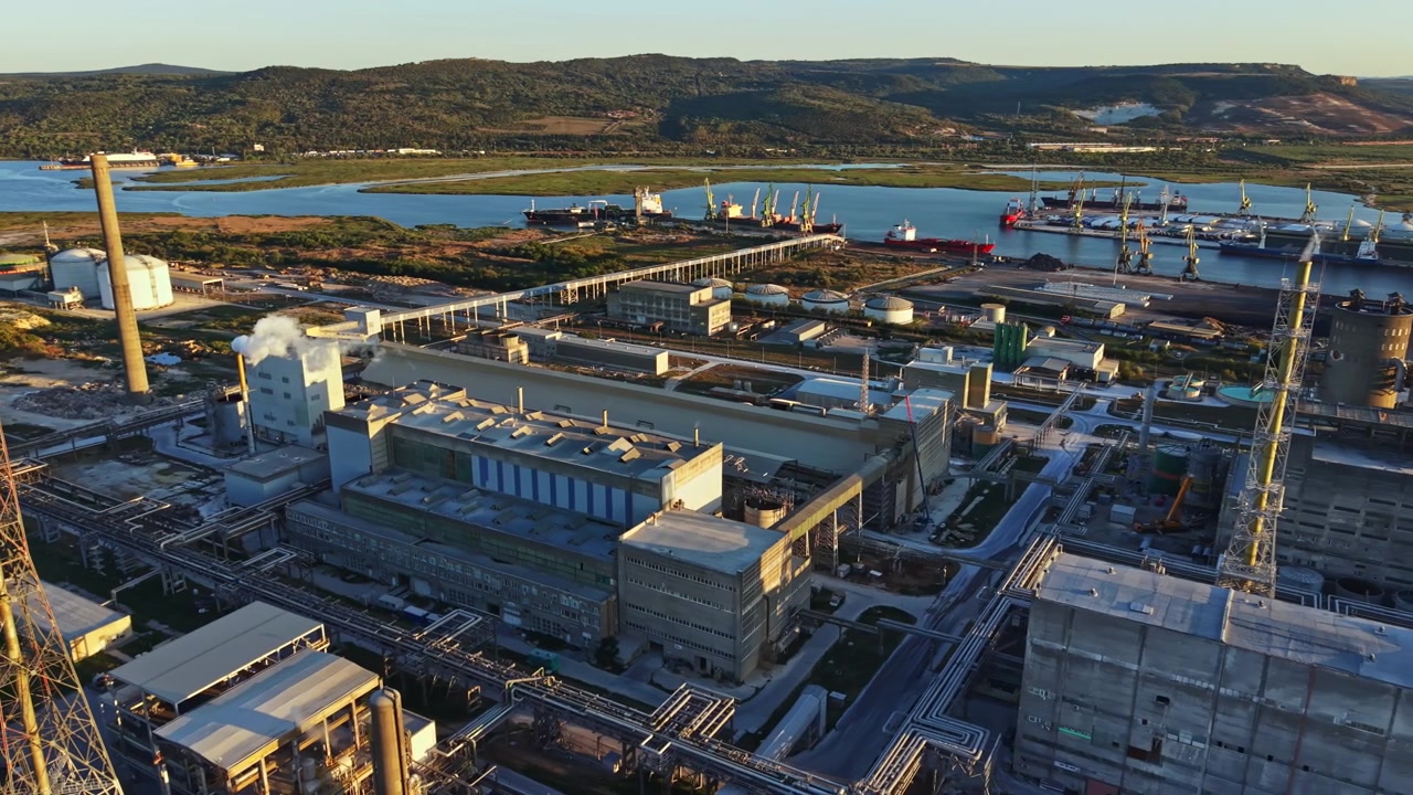 Gran complejo industrial con actividad de transporte marítimo en el agua durante el día