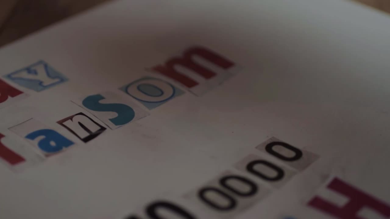 Kidnapper in black gloves making a ransom note for cash close up