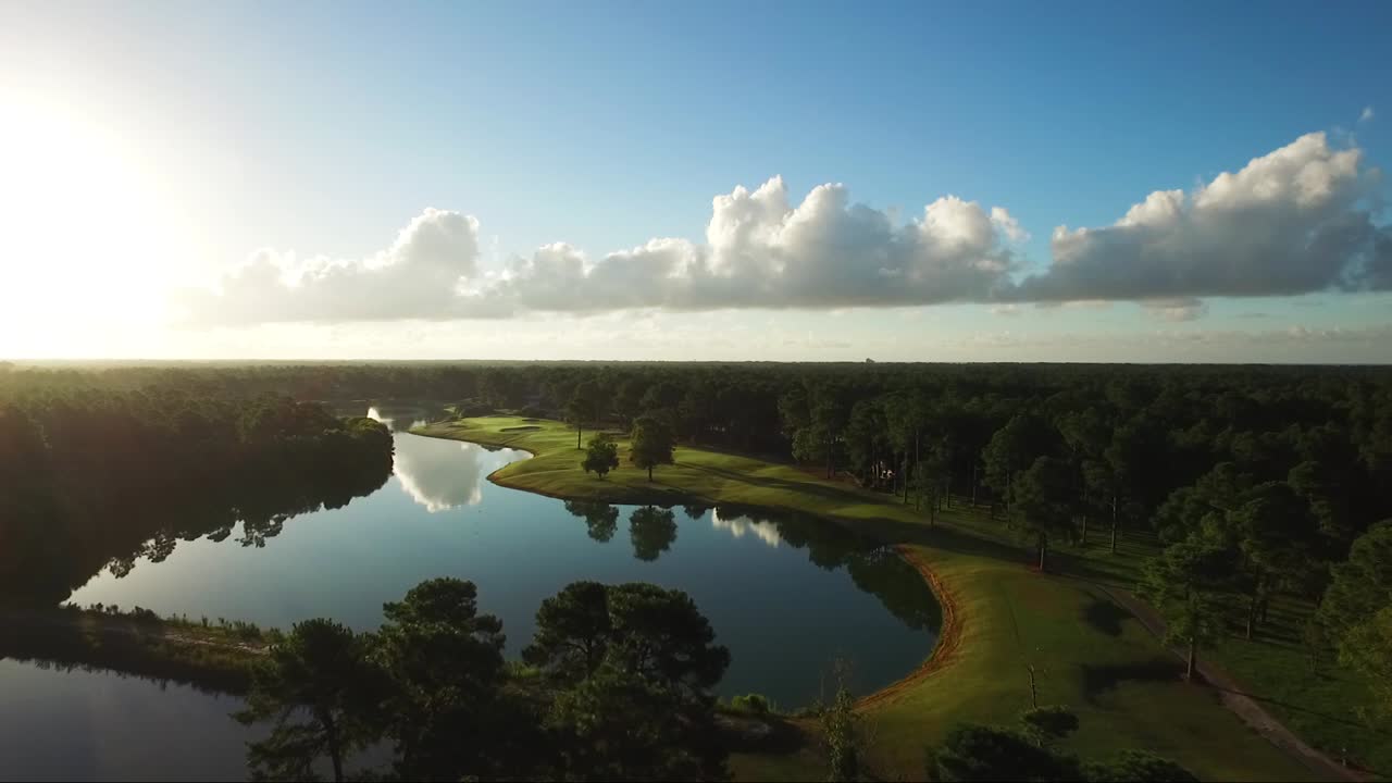 Early morning golf course with blue skies and cloud reflections in the water
