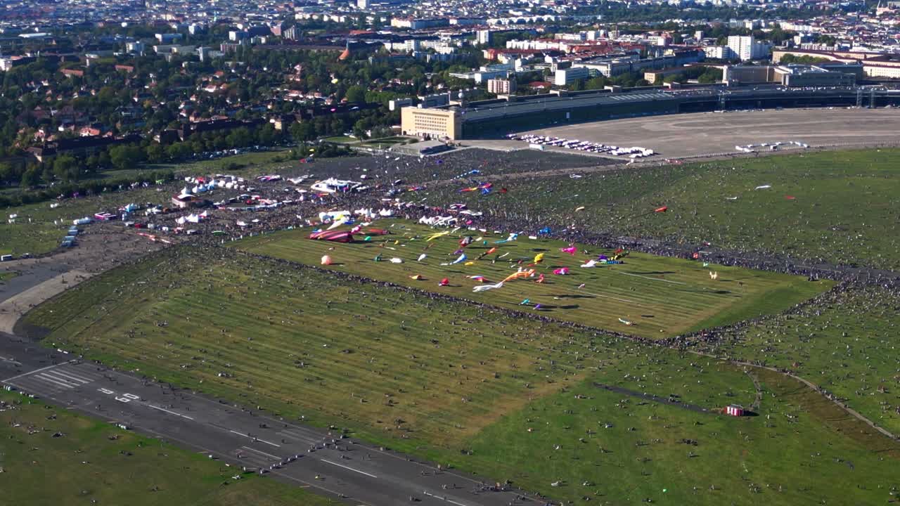 Large crowd of people gathering at the Tempelhofer Feld giant kite festival in Berlin, Germany. Wonderful aerial view flight drone top down Above view