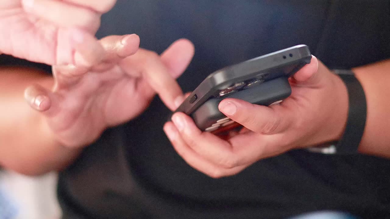 persona interactuando con su teléfono inteligente en el mercado de bangkok