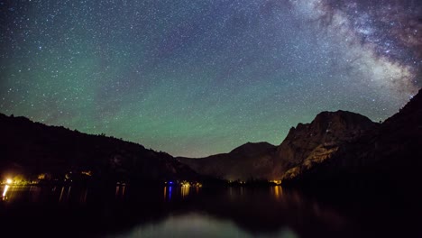 time lapse - milky way galaxy moving over the mountain range by the lake - 4k